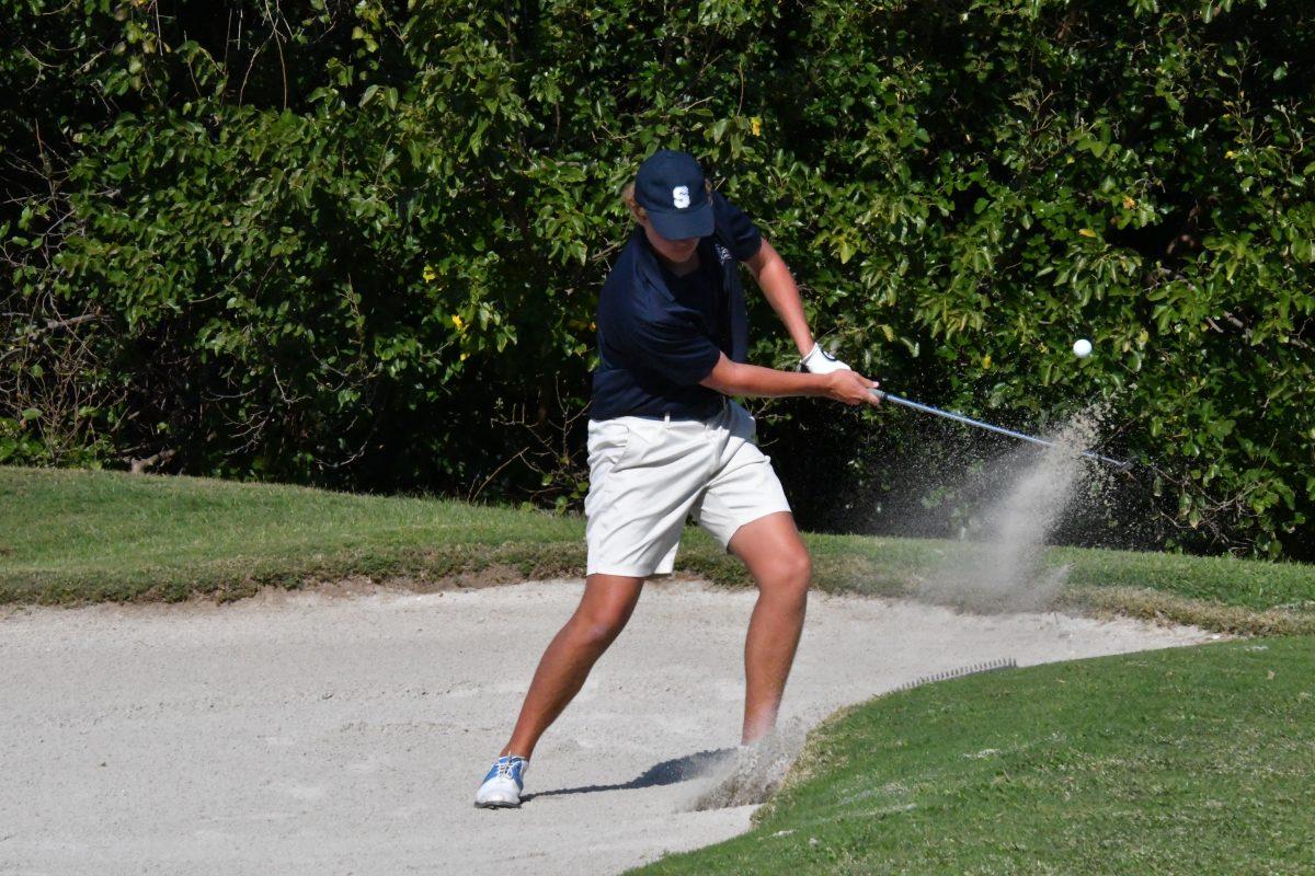 Blake Schimmels '25 chips out of a sand trap