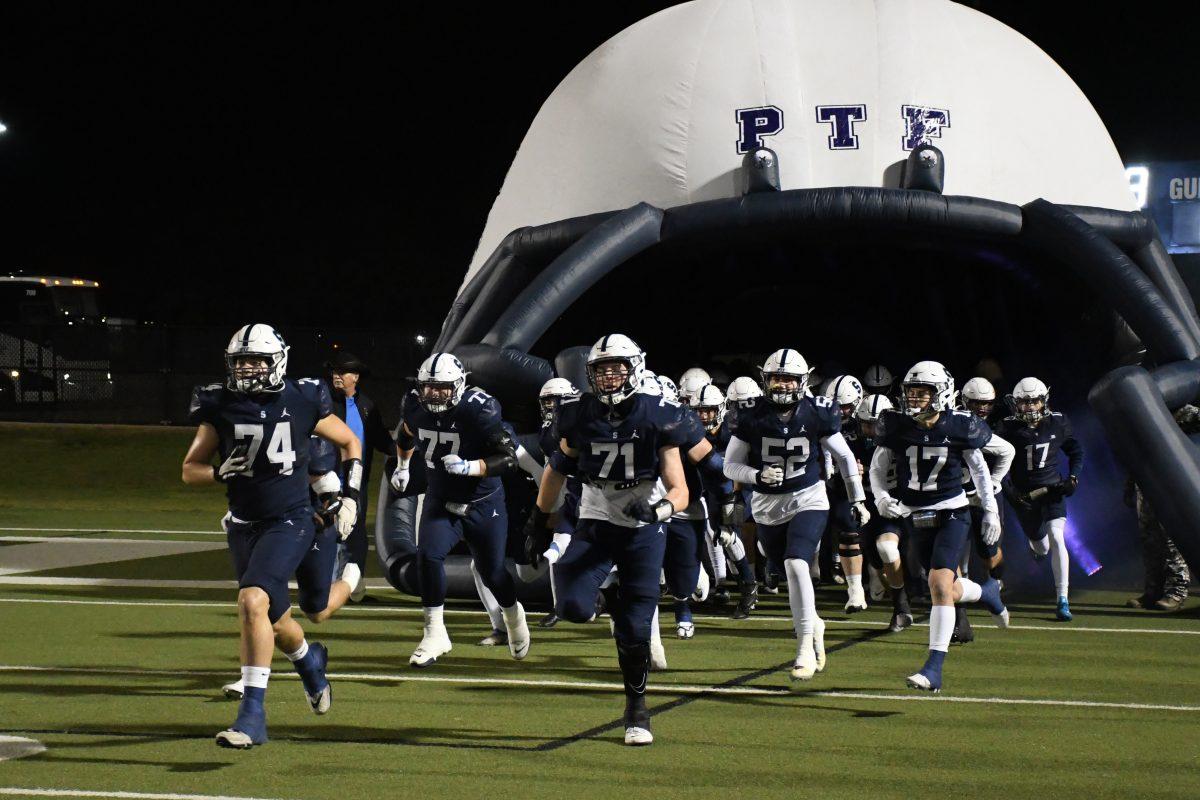 The Saints' Football Team charges onto the playing field for their playoff game against Liberty Christian