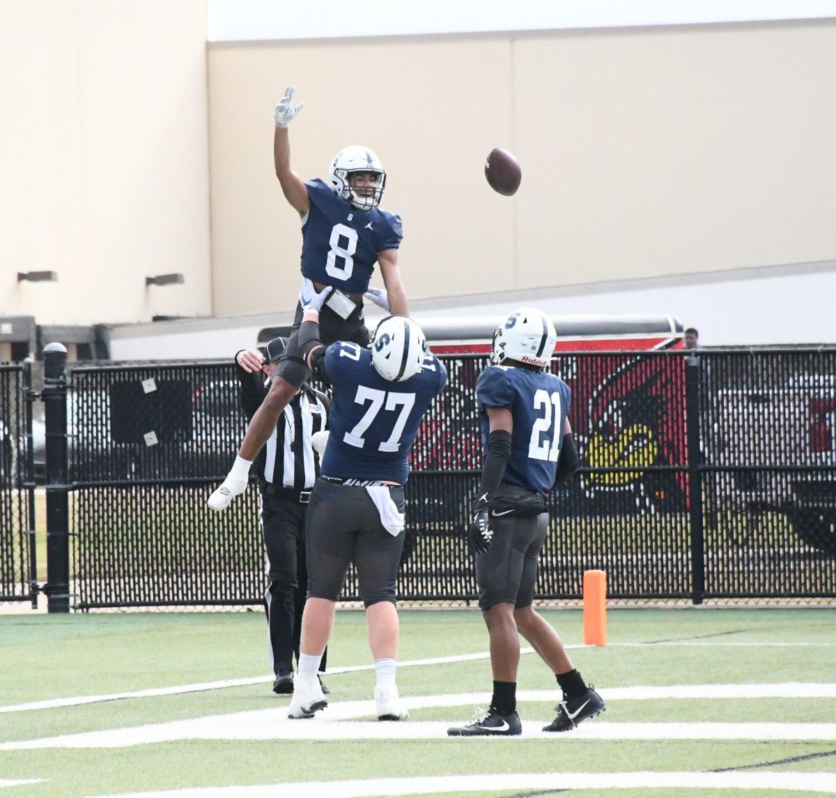 Chris Palfreeman '23 celebrates with teammates after a touchdown against Fort Worth Christian