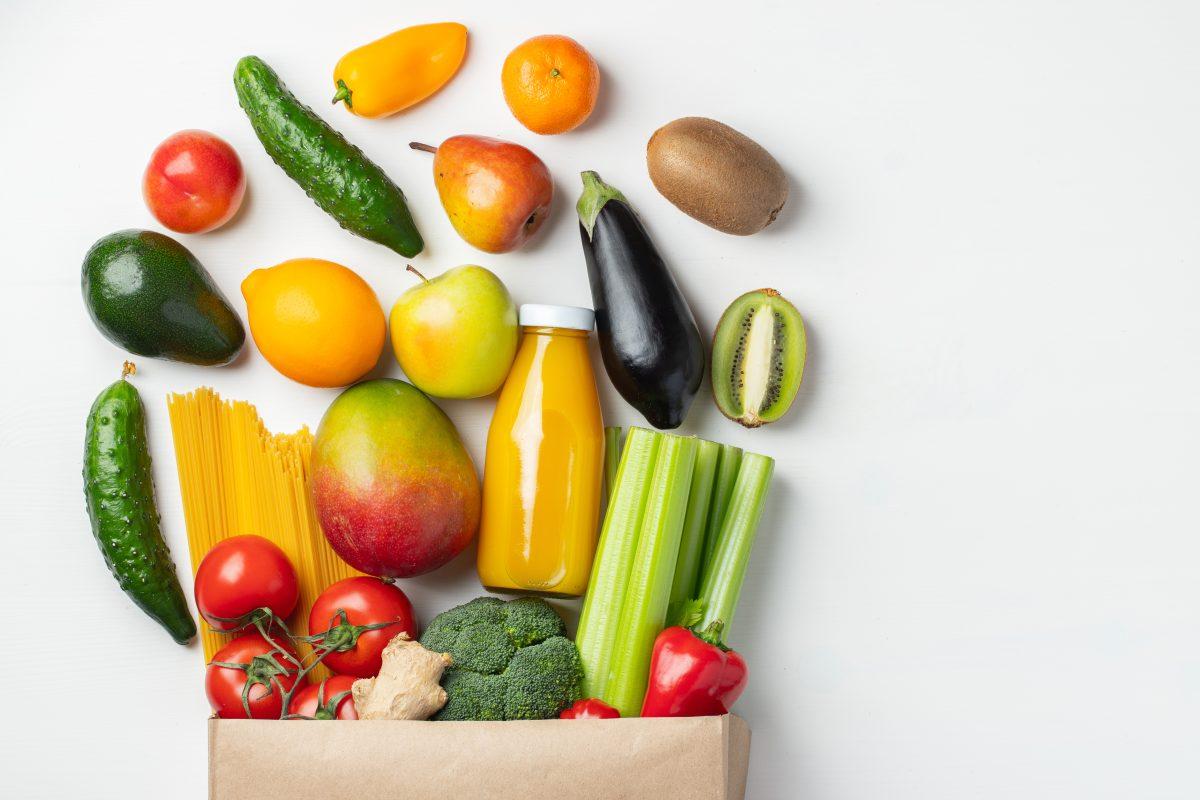 Paper bag of different health food on a white background. Top view. Flat lay. Copy space.