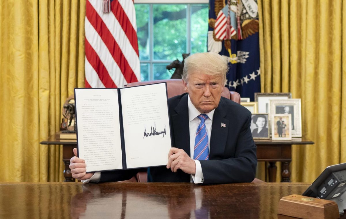 President Donald J. Trump displays his signature after signing an Executive Order on Protecting American Monuments, Memorials, and Statues and Combating Recent Criminal Violence, Friday, June 26, 2020, in the Oval Office of the White House. (Official White House Photo by Tia Dufour)